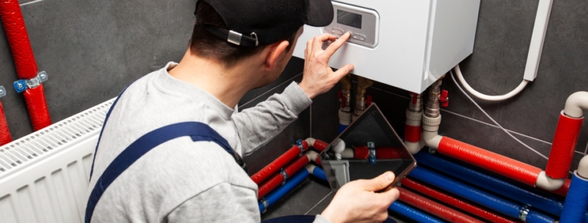 A technician checking on the status of a water heater